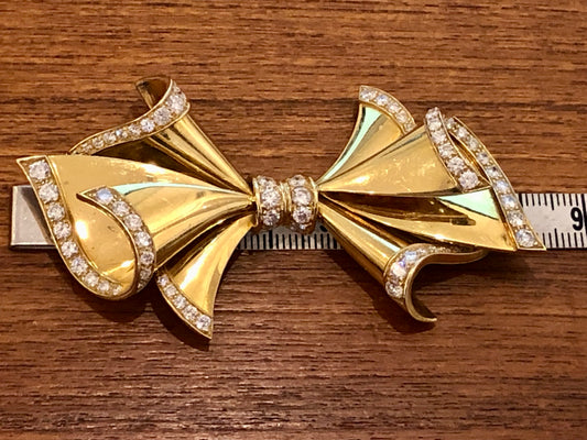 Adler Fine Jewellery. Gold and diamond bow brooch.